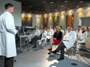 Dr. Roland Heilmann (Thomas Rühmann, links) verkündet vor versammelter Belegschaft, dass er im Moment nicht für Simonis Nachfolge infrage kommt. Als er den Interimskandidaten für die Leitung der Klinik bekannt gibt, kommt es zum Sturm der Entrüstung.