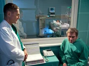 Dr. Kaminski (Udo Schenk, links) erklärt Alexander Nitschke (Michael Kind) warum seine Frau Ruth (Komparsin) auf der Intensivstation überwacht wird.