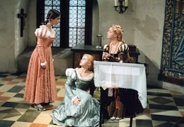 1. Die zarte und &auml;ngstliche Prinzessin Aurinia (Dana Mor&aacute;vkov&aacute;, Mi.) lebt mit ihrer selbstbewu&szlig;ten Kammerjunfer Liesa (Michaela Kuklov&aacute;, li.) wie mit einer Schwester zusammen. Auch Aurinias Mutter, die junge K&ouml;nigin (Regina Beyer, re.) ist Liesa zugetan.
