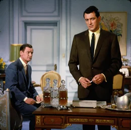 Carter (Rock Hudson, r.) unterh&auml;lt viel Unterst&uuml;tzung von seinem aus den USA angereisten Kollegen Richard (Gig Young), der die &Ouml;ffentlichkeitsarbeit in Carters Firma betreut.