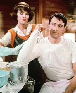 Roger (Rock Hudson), vermeintlicher Anglerexperte, l&auml;sst sich von Abby (Paula Prentiss) den Arm eingipsen, damit er sich vor dem Angelwettbewerb dr&uuml;cken kann.