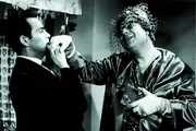 Damenimitator Egon Kummer (Heinz Erhardt, re.) hat sich als Frau verkleidet und spielt Rechsanwalt Kurt Wehling (Adrian Hover) etwas vor.