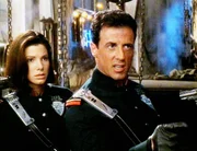 John Spartan (Sylvester Stallone) macht sich mit Lenina Huxley (Sandra Bullock) auf die Jagd nach seinem Erzfeind. John Spartan (Sylvester Stallone) macht sich mit Lenina Huxley (Sandra Bullock) auf die Jagd nach seinem Erzfeind.