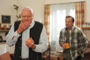 Joseph (Michael Vogtmann, links) beißt in einen Waxapfel, während Gregor (Holger Matthias Wilhelm, rechts) zuschaut.