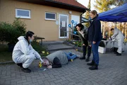 Auf dem Campingplatz "Kleinod" am Leichenfundort vor dem Waschhaus: Thomas Brandner (Yung Ngo, l.) berichtet den Kommissarinnen Pauline Hobrecht (Agnes Decker, 3.v..r.) und Tamara Meurer (Anja Pahl, 2.v.r.), dass der Tote - Frank Reinhardt (Roberto Klinke, 2.v.l.) - einen heftigen Schlag mit einem stumpfen Gegenstand bekommen hat.