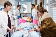 Der schwer verletzte Bernd Kaiser (Rainer Furch, M.) muss sofort operiert werden. Dass seine Freundin Bettina Bach (Bettina Kupfer, r.) ihn sehen und mit ihm sprechen will, kommt den &Auml;rzten (Katharina Nesytowa, l., Stefan Ruppe, 2.v.l., Mike Adler, 2.v.r.) nicht so gelegen.