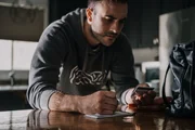 Jeff Trevino schreibt einen Scheck in der Küche.