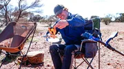 Andreas Macherey defends his breakfast against flies, in Western Australia.