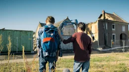 Ben (Yoran Leicher) und Tariq (Sobhi Awad) schauen zu, wie ein Haus in Bens altem Heimatdorf abgerissen wird.
