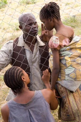 Solomon Vandy (Djimon Hounsou, M.) trifft erstmals nach der Trennung durch die Rebellen auf seine Frau Jassie Vandy  (Benu Mabhena, l.) und seine Tochter N'Yanda Vandy (Anointing Lukola, r.) ...