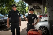 Franzi (Rhea Harder-Vennewald, r.) und Hans (Bruno F. Apitz, l.) wundern sich: Der Geldbeutel, der beim Einbruch in die Wohnung der Kramers gestohlen wurde, ist samt vollständigem Inhalt ganz in der Nähe der Wohnung entsorgt worden.