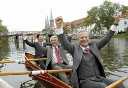 Drei Mann in einem Boot: B&uuml;rgermeister Schneider (Peter Sattmann, vorne), Bauamtsleiter Otto Schlegel (Christoph M. Ohrt, Mitte) und Pressesprecher Droller (Oliver Breite).; ARD Degeto LIEBE IM HALTEVERBOT, am Samstag (09.11.24) um 14:00 Uhr im ERSTEN. Drei Mann in einem Boot: B&uuml;rgermeister Schneider (Peter Sattmann, vorne), Bauamtsleiter Otto Schlegel (Christoph M. Ohrt, Mitte) und Pressesprecher Droller (Oliver Breite). &copy; ARD Degeto/Sandra Hoever, honorarfrei - Verwendung gem&auml;&szlig; der AGB im engen inhaltlichen, redaktionellen Zusammenhang mit genannter Degeto-Sendung und bei Nennung "Bild: ARD Degeto/Sandra Hoever" (S2). ARD Degeto/Programmplanung und Presse, Tel: 069/1509-335, degeto-presse@degeto.de
