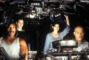 Neben Dozer (Anthony Ray Parker, l.), Trinity (Carrie-Anne Moss, 2. v. r.) und ihrem Captain Morpheus (Laurence Fishburne, r.), geh&ouml;rt auch Neo (Keanu Reeves, 2. v. l.)seit seiner Befreiung aus der Matrix zur Mannschaft der Nebuchadnedzar.