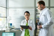 Dr. Lilly Phan (Mai Duong Kieu, mi.) hat beunruhigende Laborergebnisse ihrer Patientin bekommen. Der Mann der Patientin wird von Dr. Kai Hoffmann (Julian Weigend, re.) behandelt. Nun m&uuml;ssen die beiden &Auml;rzte eine schwere Nachricht &uuml;berbringen.