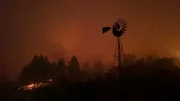 The North Star Ranch windmill at night surrounded by fire.