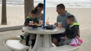 Contributors Kyle Seger (CR) and Jessica Seger (CL) enjoy some snacks on the beach with their sons Kristian Seger (R) and Kolten Seger (L) as seen on HGTV's Beachfront Bargain Hunt.