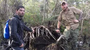 Grady Powell and Bill McConnell next to an upturned tree in a swamp in Cuba.