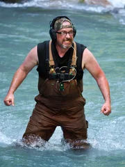 Gold Rush: White Water. Rich Webster stands in the water.