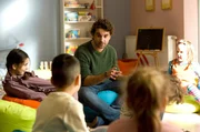Erzieher Freddy (Oliver Wnuk) ermuntert die Kinder, die Spielsachen an einen anderen Ort zustellen. Erzieher Freddy (Oliver Wnuk) ermuntert die Kinder, die Spielsachen an einen anderen Ort zustellen.