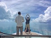 Foto hinter den Kulissen, als Rob (l.) und Stefan (r.) eine Drohne von der Rückseite ihres Bootes vor der Küste von Bimini starten. Foto hinter den Kulissen, als Rob (l.) und Stefan (r.) eine Drohne von der Rückseite ihres Bootes vor der Küste von Bimini starten.