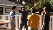 Antonio Bellatore with his arms triumphantly in the air stands with Francesca Cappucci and her sons, Will and Ian, on the remodeled deck.