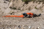 Ayr, ON - REENACTMENT - Pilot, gespielt von einem Hintergrunddarsteller, liegt verletzt in der Mojave-W&uuml;ste, weit weg vom Wrack der Virgin Galactic SS2. (Cineflix 2017/Darren Goldstein)