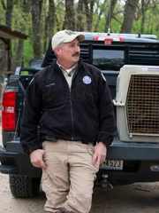 Conservation Officer leaning against his truck.