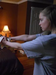 Cinnamon aims a gun at Linda while she is asleep in bed. Cinnamon aims a gun at Linda while she is asleep in bed.