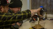 Rick Ness (l.) pouring gold as Bailey Carten reads scale, gold weigh