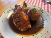 Die Hauptspeise Schweinshaxe mit gebackenen Knödeln im Gasthof Muhr.