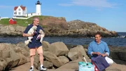 Contributors Kenny Baublitz (L) and Joe Knapp (R) set up a picnic with their dogs overlooking the Nubble Lighthouse in York, Maine as seen on HGTV's Beachfront Bargain Hunt.