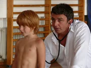 Martin (Hans Sigl, r.) untersucht den Drittklässler Lukas Beisel (Timon Riedelbauch), der offenbar von seinem Vater geschlagen wird.