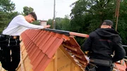 Dachdecker-Azubi Simeon sucht hoch auf dem Dach nach dem sicheren Tritt. Dachdecker-Azubi Simeon sucht hoch auf dem Dach nach dem sicheren Tritt.