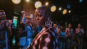 Mother Calista (Florence Kasumba, vorne) verfolgt auf Lias Kiki-Ball eine ganz eigene Agenda. Im Hintergrund befindet sich die tanzende Community (Komparsen). Mother Calista (Florence Kasumba, vorne) verfolgt auf Lias Kiki-Ball eine ganz eigene Agenda. Im Hintergrund befindet sich die tanzende Community (Komparsen).