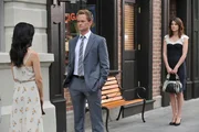 Nachdem Barney (Neil Patrick Harris, M.) und Robin (Cobie Smulders, r.) die Sprengung gesehen haben, sagt sie ihm, dass sie stolz auf ihn sei. Doch ihr Gespräch endet abrupt, als auf einmal Nora (Nazanin Boniadi, l.) vor ihnen steht ...