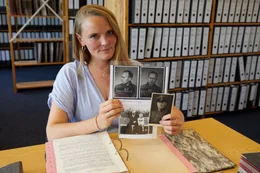 Maria Holzgrewe mit Familienfotos, die ihren Urgro&szlig;vater Wilhelm Dreimann zeigen &ndash; darunter auch ein Bild mit seiner Tochter. Dreimann wurde von den H&auml;ftlingen "Henker von Neuengamme" genannt, da er Hinrichtungen gerne eigenh&auml;ndig durchf&uuml;hrte.