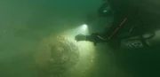 Ein Taucher beleuchtet die gefundenen Wrackteile
