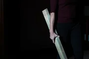 Eine Person h&auml;lt ein Holzbrett.