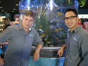 Pembroke Pines, Florida, USA:  Jose and Francis smile in front of their Sausage Tree tank.