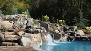 Peek Pools and Spas added a slide and rock work to the pool, as seen on Pool Kings.