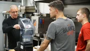 Chef Robert Irvine shows The Balanced Chef owner, Brian Donovan, along with kitchen manager, Kent Vedder, how to make new menu items, as seen on Restaurant Impossible, season 20 Chef Robert Irvine shows The Balanced Chef owner, Brian Donovan, along with kitchen manager, Kent Vedder, how to make new menu items, as seen on Restaurant Impossible, season 20