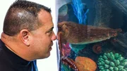 Wayde King looking closely into Tracy's octopus tank with his nose up against the glass.