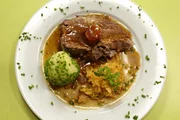 Schweinsbraten mit Bratensauce, Kartoffelknödeln und saures Rahmkraut.
