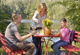 Anna Kramer (Ursula Buschhorn, Mitte) hat Fr&uuml;hst&uuml;ck zubereitet f&uuml;r Nick (Michael von Au) und seine kleine Tochter Isabelle (Luisa Neuh&auml;user).; ARD Degeto DER SEE DER TR&Auml;UME, am Sonntag (06.10.24) um 14:03 Uhr im ERSTEN. Anna Kramer (Ursula Buschhorn, Mitte) hat Fr&uuml;hst&uuml;ck zubereitet f&uuml;r Nick (Michael von Au) und seine kleine Tochter Isabelle (Luisa Neuh&auml;user). &copy; ARD Degeto/Reiner Bajo, honorarfrei - Verwendung gem&auml;&szlig; der AGB im engen inhaltlichen, redaktionellen Zusammenhang mit genannter Degeto-Sendung und bei Nennung "Bild: ARD Degeto/Reiner Bajo" (S2). ARD Degeto/Programmplanung und Presse, Tel: 069/1509-335, degeto-presse@degeto.de