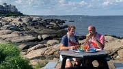 Contributors Bob Gentile (R) and Will Sweet (L) enjoy some Maine lobsters on the water on a gorgeous summer afternoon as seen on HGTV's Beachfront Bargain Hunt.