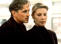 Der selbstherrliche Finanzmakler Nicholas Van Orton (Michael Douglas) ahnt noch nicht, dass bald seine Existenz in Scherben liegen wird. Ist die geheimnisvolle Blondine Christine (Deborah Kara Unger, re.) Teil einer Verschw&ouml;rung?.
