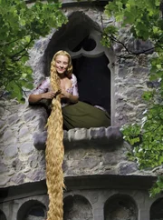 Rapunzel (Luisa Wietzorek) sitzt im Fenster ihres Turms und kämmt ihr blondes Haar.