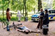Die Kommissarinnen Lilly Funke (Tatjana Kästel, l.) und Vanessa Haas (Kerstin Landsmann, 2.v.r.) sind mit Rechtsmedizinerin Dr. Pilar Westphal (Yulia Yáñez Schmidt, r.) am Tatort des erschossenen Timo Röder (Lukas Hunecker, M.). (Komparsin im Bild) Die Kommissarinnen Lilly Funke (Tatjana Kästel, l.) und Vanessa Haas (Kerstin Landsmann, 2.v.r.) sind mit Rechtsmedizinerin Dr. Pilar Westphal (Yulia Yáñez Schmidt, r.) am Tatort des erschossenen Timo Röder (Lukas Hunecker, M.). (Komparsin im Bild)