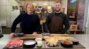 Spitzenkoch Björn Freitag (l.) und der Grill-Blogger und Unternehmer Joscha Bastians (r.) bereiten in dessen Grillschule Pulled Pork und Huhn für den Smoker vor.