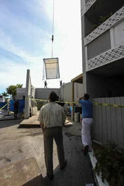 The clients watch from afar as ATM lifts their new aquarium.